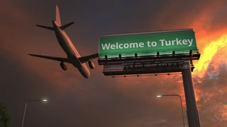 Arriving plane flies above WELCOME TO TURKEY